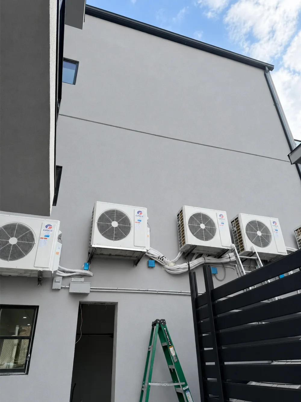 住宅外墙整齐安装的多台格力分体空调室外机